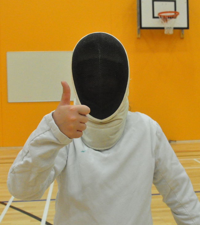 Picture of a young fencer waring a mask and giving thumbs-up
